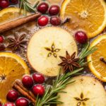 Ultra close-up macro shot of simmering autumn pot with apples, oranges, cranberries and cinnamon