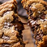 Ultra close-up macro of warm chewy brown butter chocolate chip cookies pulled apart with melted chocolate