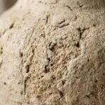 Macro texture of handcrafted textured stone ceramic vase showing travertine limestone details