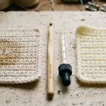 Close-up macro of chunky Suzette crochet blanket stitches with 8.0 mm birch hook and wooden ruler on travertine workbench