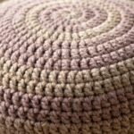 Ultra close-up macro photograph of handcrafted chunky crochet floor pouf ottoman showing thick half double crochet spiral stitch texture