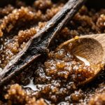 Ultra close-up macro texture of rich dark brown sugar body scrub mixed with golden sweet almond oil