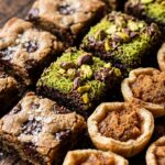 Ultra close-up macro of bite-sized autumn party desserts including chocolate pistachio brownie bites and brown butter cookie bars