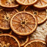 Ultra close-up macro texture of translucent amber oven-dried orange slices on parchment baking sheet
